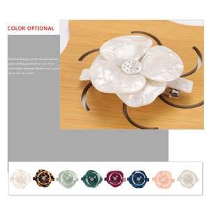 Detail of camellia hair clip showing 8 colors and acetate texture with rhinestones