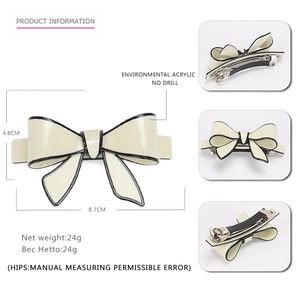 Elegant acrylic bow hair clip in cream with black edging and metal spring fastener