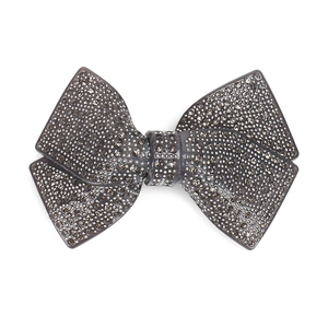 Close-up of elegant acrylic bow hair clip with charcoal rhinestones and spring clamp