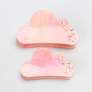 Detail of pink cloud-shaped hair claws with glitter, colorful rhinestones and pearl pendant