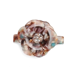 Detailed macro view of acetate tortoise flower hair clip with sparkling rhinestones