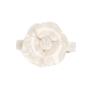 Detailed view of acetate camellia hair clip with glossy silk finish and crystal center