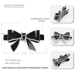 Minimalist black acrylic bow hair clip with white trim and spring fastener for women