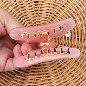 Close-up of pink marbled acrylic claw clip with strong metal teeth and pearl charm
