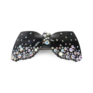 Détail d'une pince à cheveux nœud en acrylique noir avec des strass AB scintillants