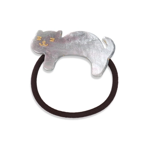Macro shot of sleeping cat resin hair tie with marble texture and golden glitter details