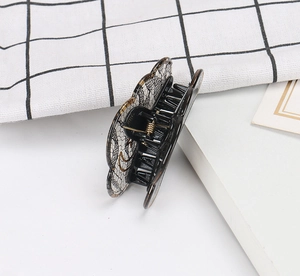 Detail view of a black butterfly hair claw clip with elegant lace texture and metal spring