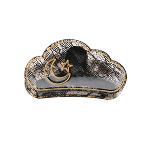 Close-up of cloud-shaped hair claw with black lace texture and gold moon star details