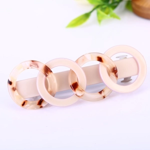 Minimalist acetate hair clip with interlocking cream and amber resin rings on silver base