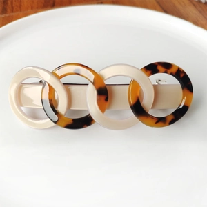 Close-up of interlocking acetate rings hair clip with tortoiseshell and ivory patterns