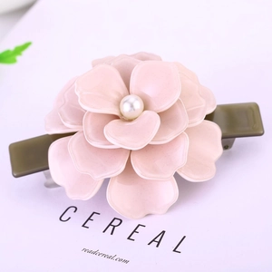 Barrette fleur camélia rose élégante multicouche avec perle centrale sur carte