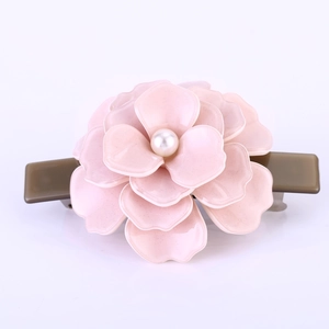 Détail de la pince à cheveux camélia rose avec centre perle et base en acétate