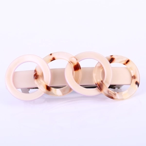 Close-up of interlocking acetate rings on a spring hair clip with tortoiseshell pattern