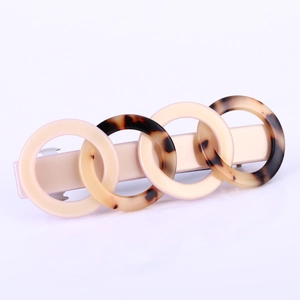 Detail of tortoiseshell and cream acetate linked rings on a golden spring hair clip