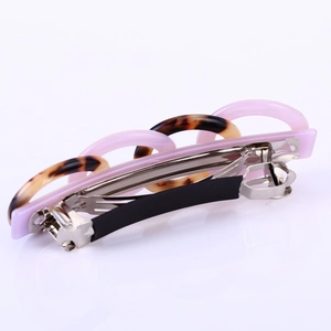 Detail view of pink and tortoiseshell resin link spring hair clip with silver metal base