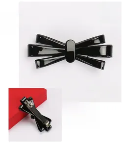 Dettaglio del fermaglio per capelli a fiocco in acetato nero lucido con molla in metallo 10x4cm