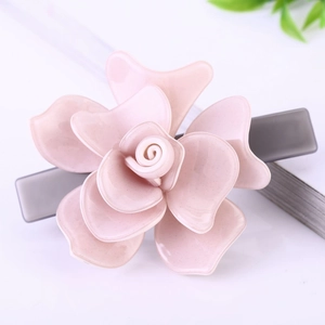 Détail d'une pince à cheveux fleur de camélia rose multicouche avec finition scintillante