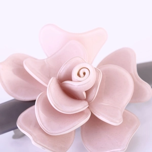 Vue détaillée d'une pince à cheveux fleur rose multicouche avec finition glacée