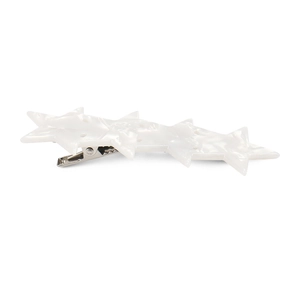 Detail of white acetate star hair clip with pearlescent texture and metal duckbill grip