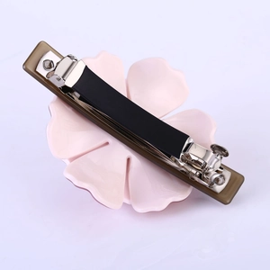 Détail de la pince à cheveux camélia en acétate rose avec fermoir à ressort en métal