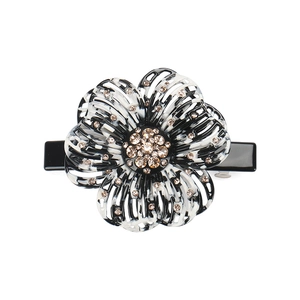 Detail view of flower hair clip featuring black and white marble petals and crystals