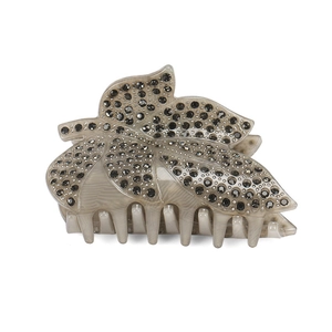 Κοντινή λήψη κλαμερ μαλλιών σε σχήμα φύλλου με γκρι μάρμαρο και λαμπερά στρας