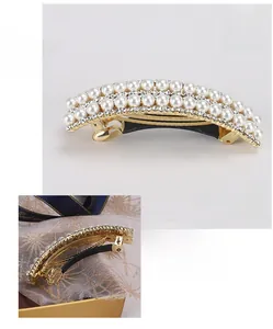Close-up detail of a pearl and rhinestone hair clip with 8.8x2cm dimensions displayed