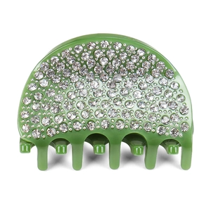 Dettaglio di un fermaglio per capelli in resina verde erba con strass bianchi lucidi