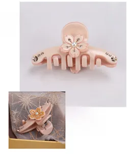 Dettaglio del fermaglio per capelli a fiore in acetato con strass e perla centrale