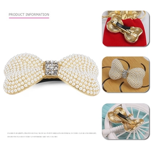 Pince à cheveux élégante avec perles blanches et strass brillants sur base dorée