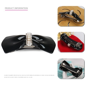 Vintage black bow hair clip with pearls and rhinestones on a white background