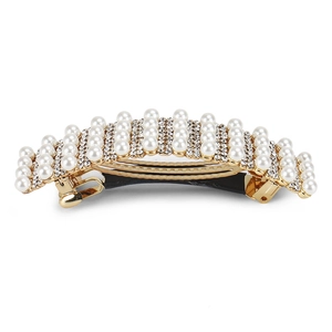 Macro shot of elegant pearl hair clip with rhinestones on a gold metal spring clasp