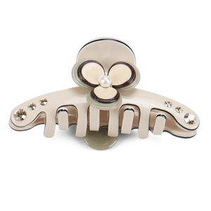 Detailed macro view of a floral acetate hair claw clip with pearls and rhinestones