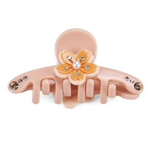 Dettaglio molletta per capelli in acetato rosa con fiore giallo, perla e strass lucidi