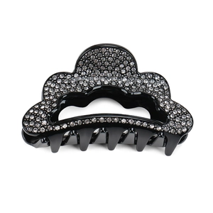 Vue détaillée de la pince à cheveux ondulée en acrylique noir avec strass brillants