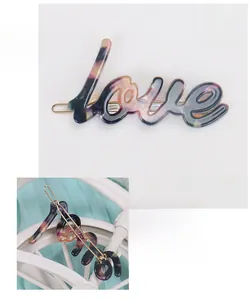 Detail view of acetate love letter hair clip with purple marble texture and gold metal base