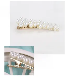 Macro shot of faux pearl acetate duckbill clip detailing the elegant golden alloy texture