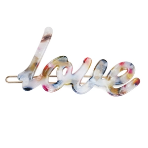 Close-up of colorful Love letter hair clip made of acetate with golden metal fastener