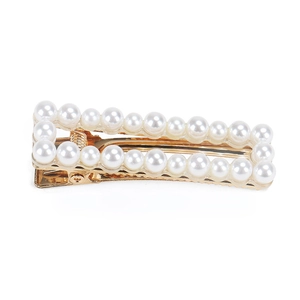 Detailed view of rectangular faux pearl hair clip with polished gold metal base