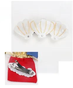 Vue détaillée de la barrette en acétate en forme de coquillage avec strass et clip