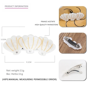 Barrette à cheveux élégante en acétate blanc avec coquillages dorés et cristaux brillants