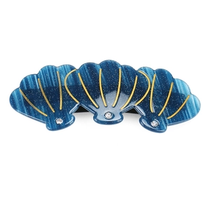 Détail d'une barrette coquillage bleue avec bordures dorées et strass brillants