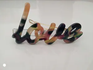 Detailed view of the Love letter hair clip featuring colorful acetate marble textures
