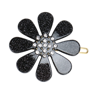 Detailed view of the black sequin flower hair clip with sparkling white rhinestones