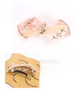 Detailed views showing bow-shaped acetate hair clip with rhinestones and size measurements