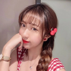 Cute red cherry hair clip with green leaves accessory worn by model in plaid shirt