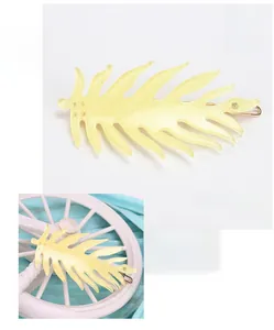 Macro detail of yellow acetate leaf hair clip with shiny glitter finish and small rhinestone