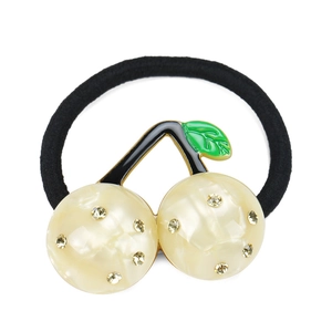Detailed close-up of cream cherry hair clip with acetate texture and small rhinestones