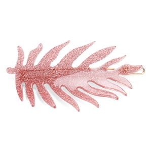 Close-up of pink glitter leaf hair clip with golden metal clip on white background