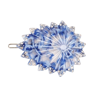 Détail d'une pince à cheveux étoile de mer en résine marbrée bleue avec des strass brillants